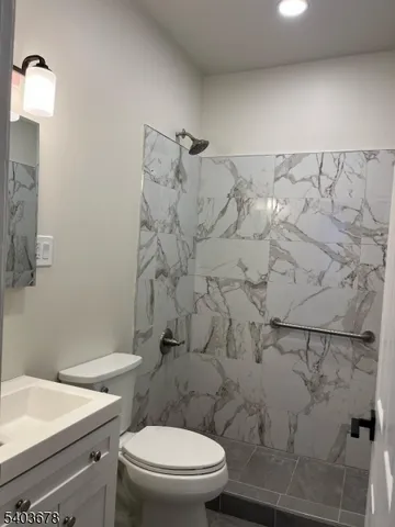 a white toilet sitting next to a bath tub