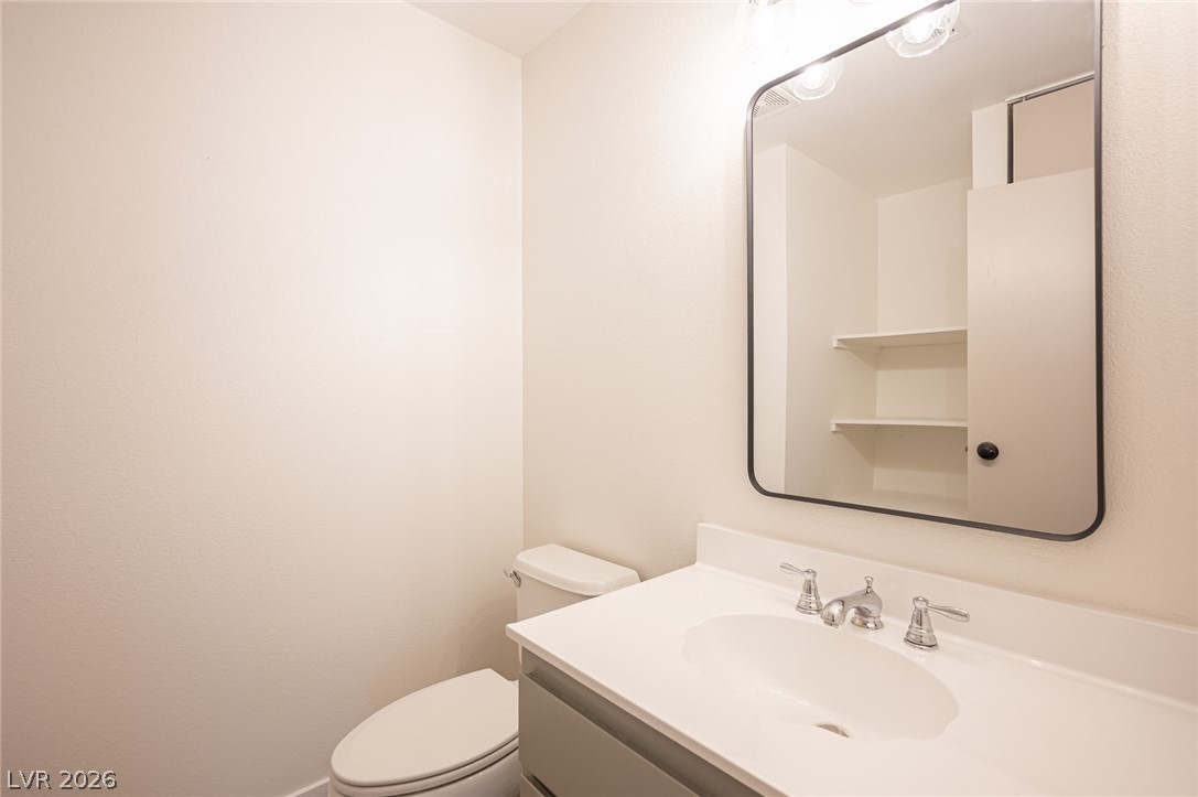7041 North Decatur Boulevard Las Vegas, NV 89131 - Photo 25 of 33 A well-lit powder room offers functional vanity and toilet.