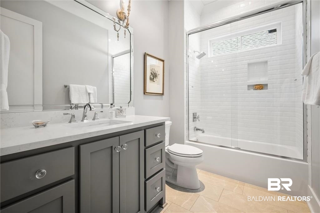 707 Cardamel Court Fairhope, AL 36532 - Photo 25 of 40 Full bathroom with bath / shower combo with glass door, tile patterned floors, toilet, and vanity