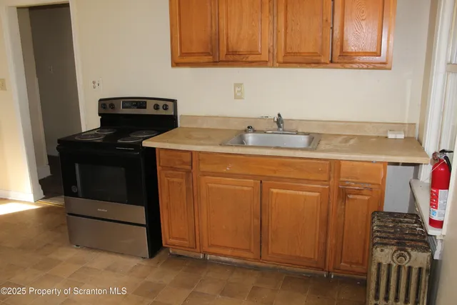 a kitchen with granite countertop a stove and a sink