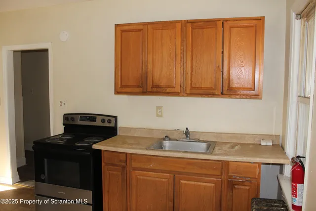 a kitchen with granite countertop a sink stove and cabinets