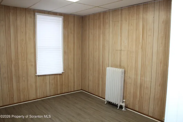 an empty room with wooden floor and a window