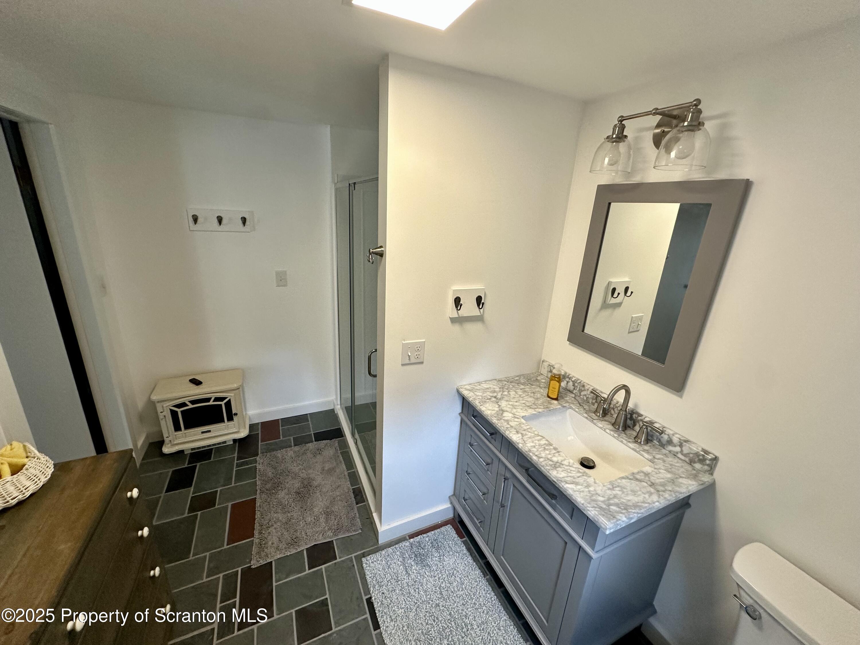 1033 Sugar Hollow Road Tunkhannock, PA 18657 - Photo 21 of 27 a bathroom with a sink a toilet a mirror and vanity