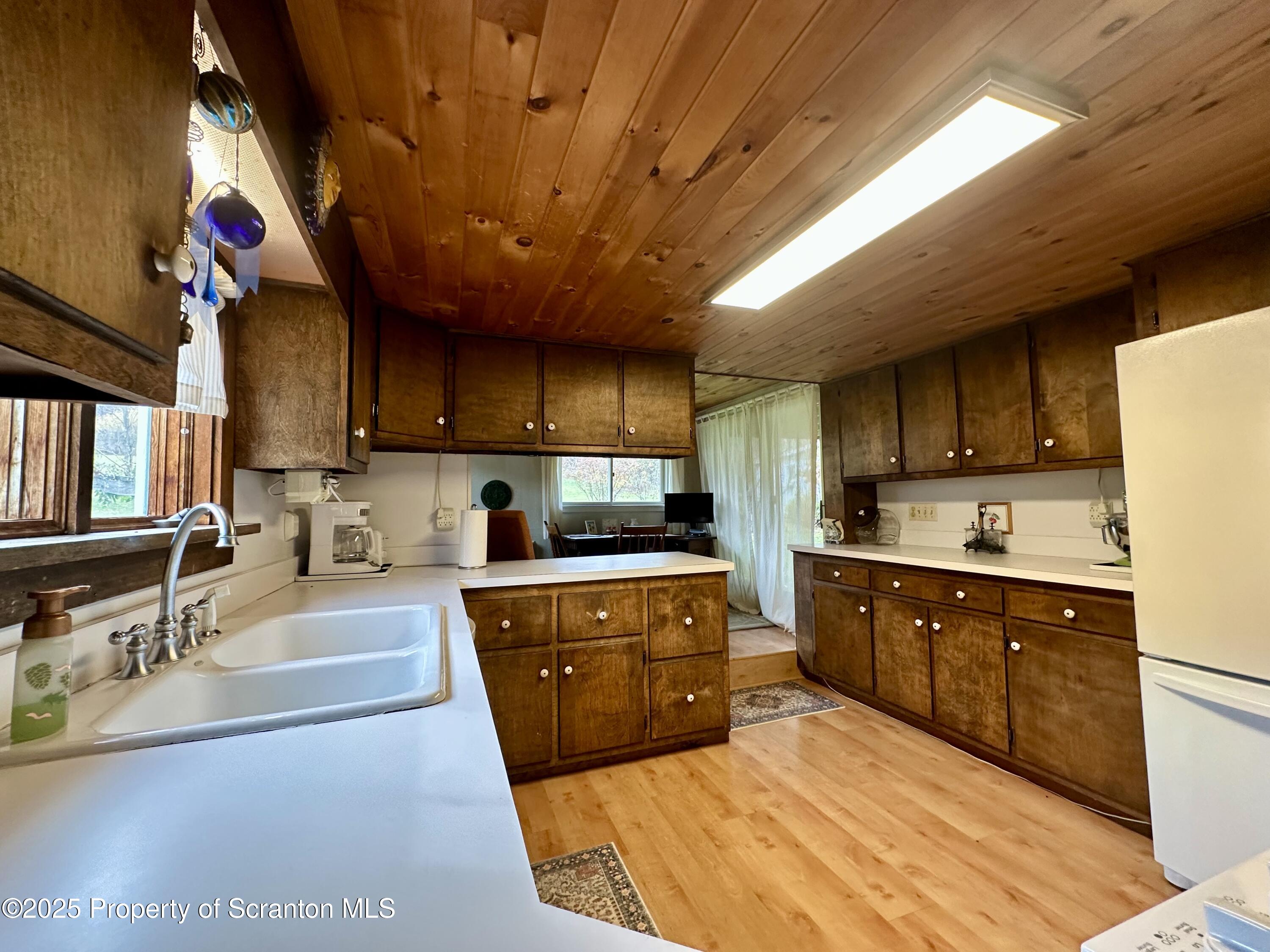 1033 Sugar Hollow Road Tunkhannock, PA 18657 - Photo 6 of 27 a kitchen with stainless steel appliances granite countertop a sink dishwasher stove and refrigerator with wooden floor