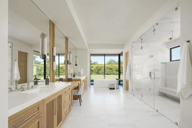 a large white room with a large window and stainless steel appliances