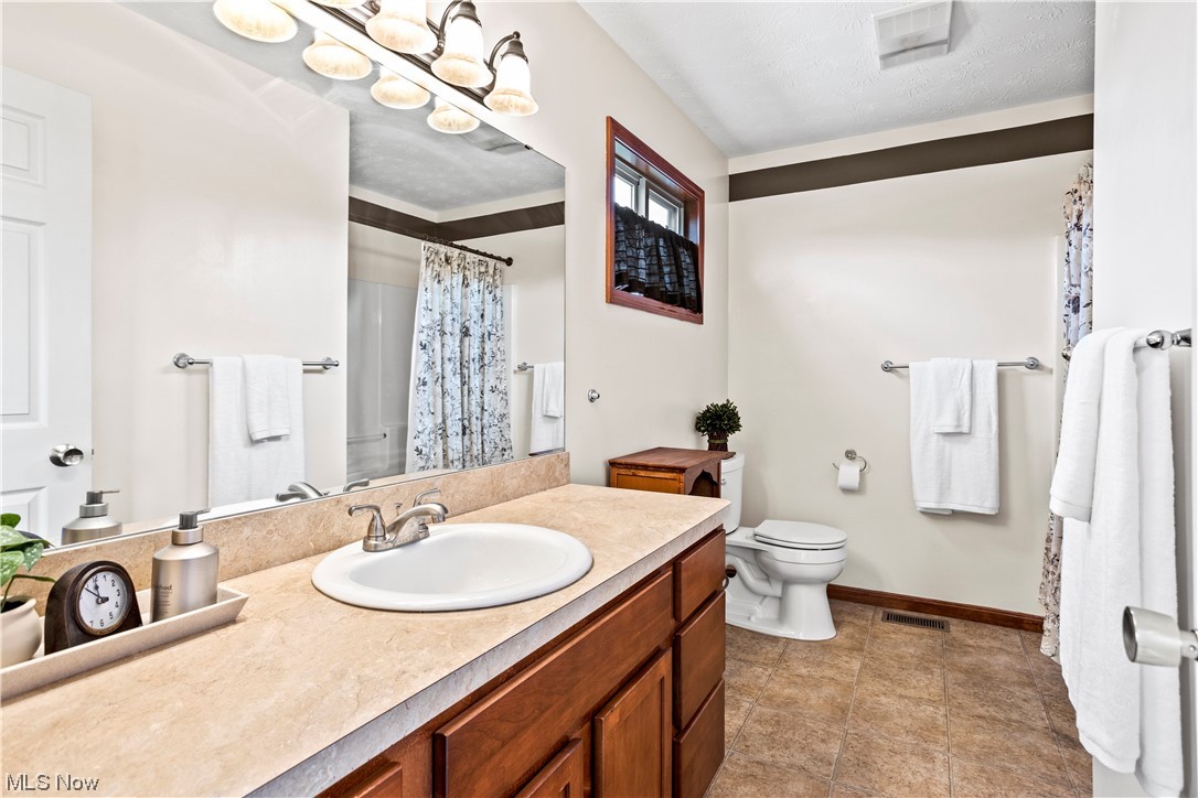 9240 Murray Ridge Road Elyria, OH 44035 - Photo 16 of 34 Bathroom with vanity, mirror, and light tile floors