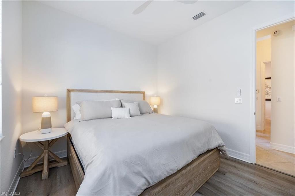 13459 Sumter Lane Naples, FL 34109 - Photo 14 of 33 a bedroom with a bed and a lamp