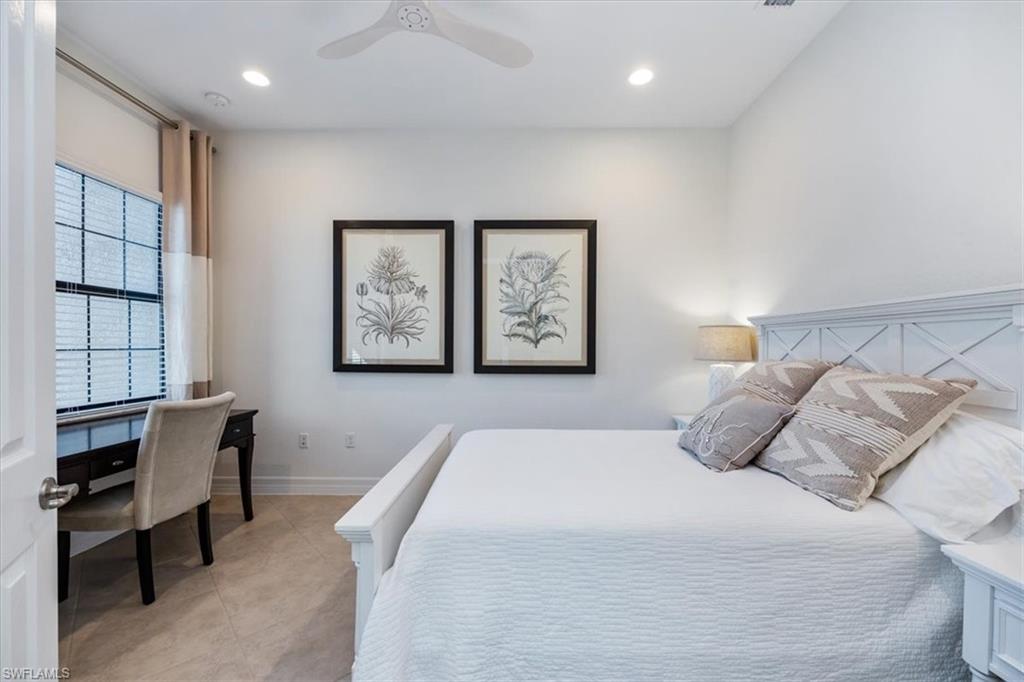 13459 Sumter Lane Naples, FL 34109 - Photo 16 of 33 a bedroom with a large bed and a desk