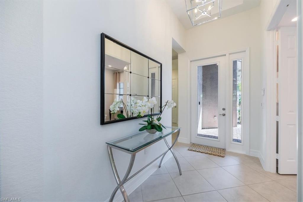 13459 Sumter Lane Naples, FL 34109 - Photo 3 of 33 a view of a hallway with wooden floor and a living room