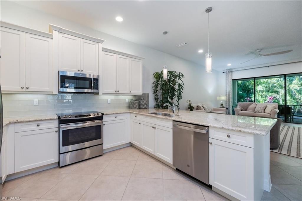 13459 Sumter Lane Naples, FL 34109 - Photo 33 of 33 a kitchen with granite countertop white cabinets and white appliances