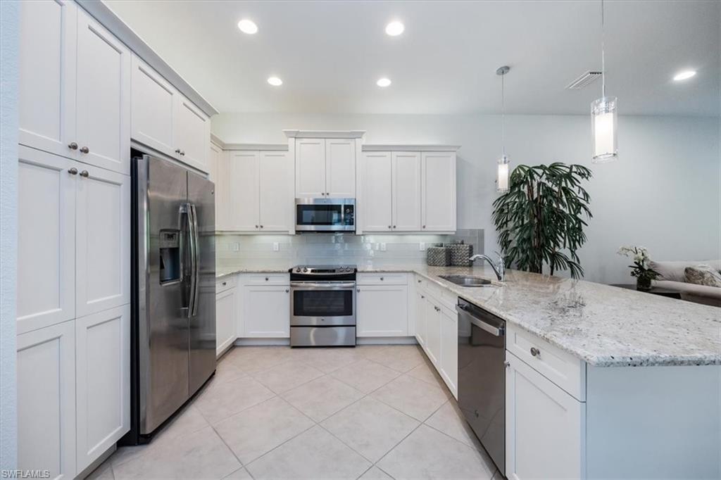 13459 Sumter Lane Naples, FL 34109 - Photo 7 of 33 a kitchen with stainless steel appliances granite countertop a refrigerator sink and stove
