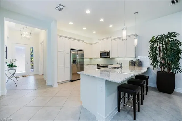 a kitchen with stainless steel appliances granite countertop a refrigerator sink and stove