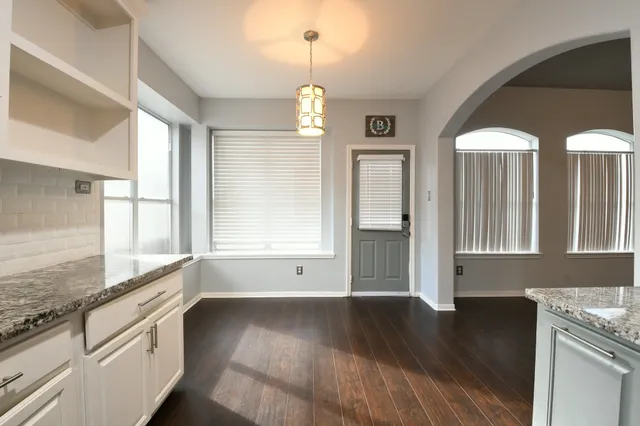 a view of a kitchen with granite countertop a large window cabinets and stainless steel appliances