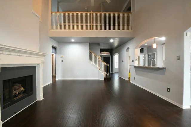 a view of a livingroom with wooden floor and a fireplace