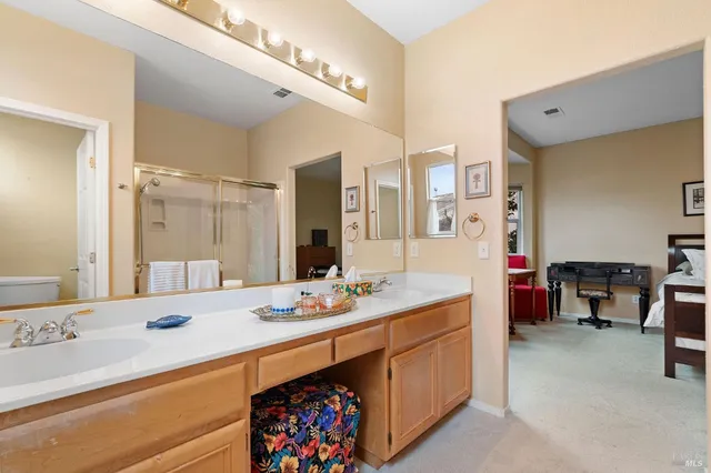 a spacious bathroom with a double vanity sink a mirror and a bathtub