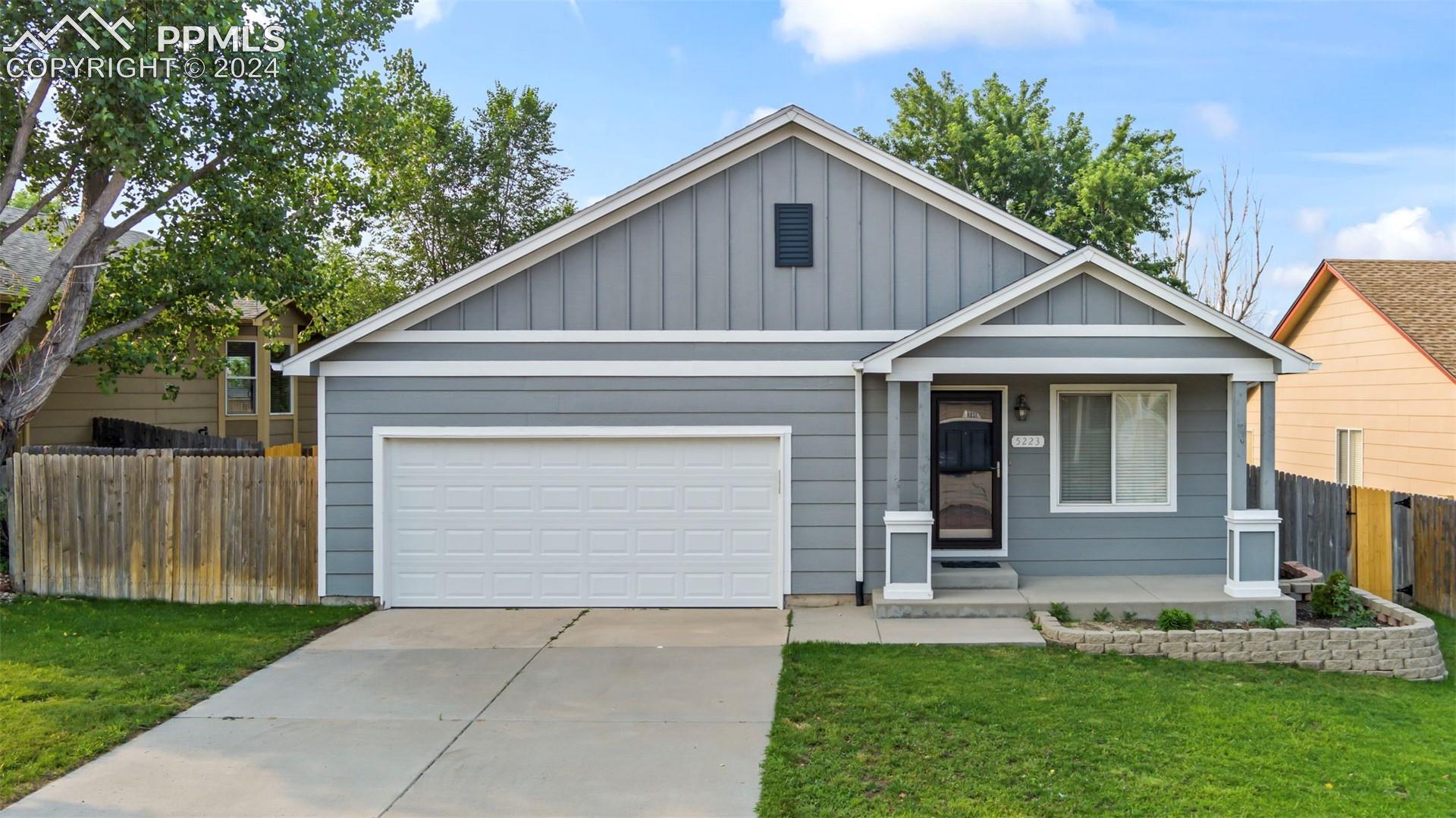 View of front of house featuring a garage and a front lawn
