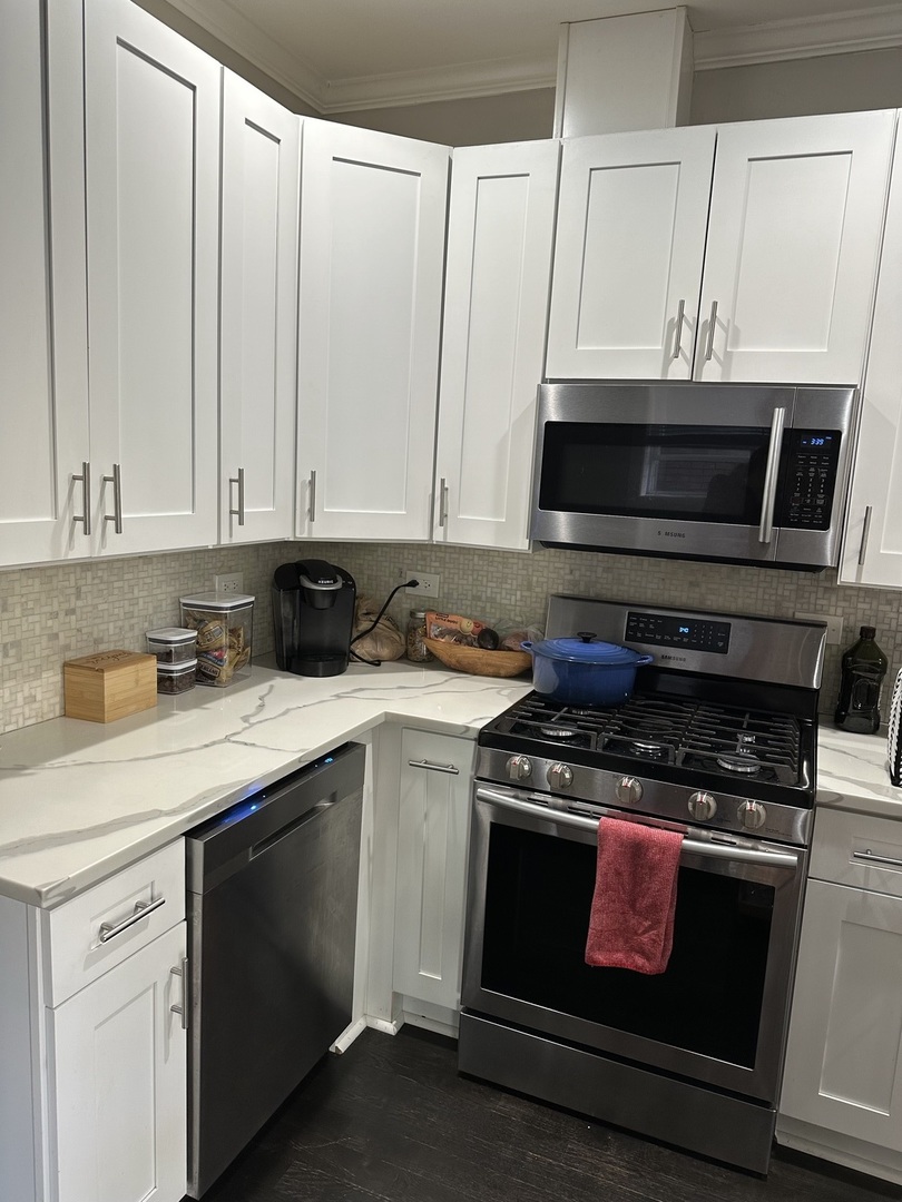 2138 West Shakespeare Avenue, Unit 1 Chicago, IL 60647 - Photo 5 of 14 a kitchen with stainless steel appliances a stove a microwave and sink