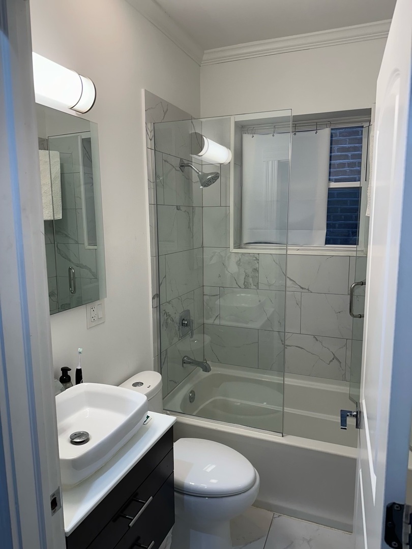 2138 West Shakespeare Avenue, Unit 1 Chicago, IL 60647 - Photo 10 of 14 a bathroom with a sink a toilet and shower