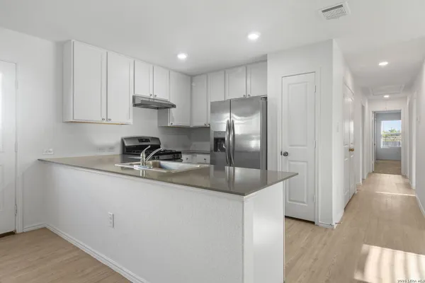 a kitchen with stainless steel appliances granite countertop a refrigerator and a sink