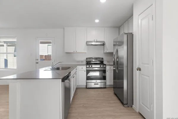 a kitchen with stainless steel appliances a refrigerator stove and sink
