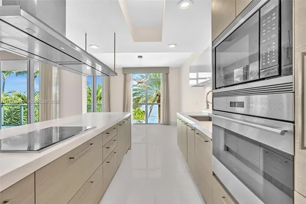 a large white kitchen with a large window