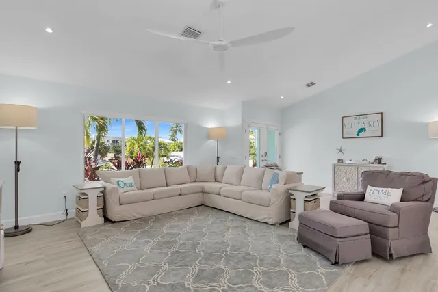 a kitchen with stainless steel appliances kitchen island granite countertop a dining table chairs and white cabinets