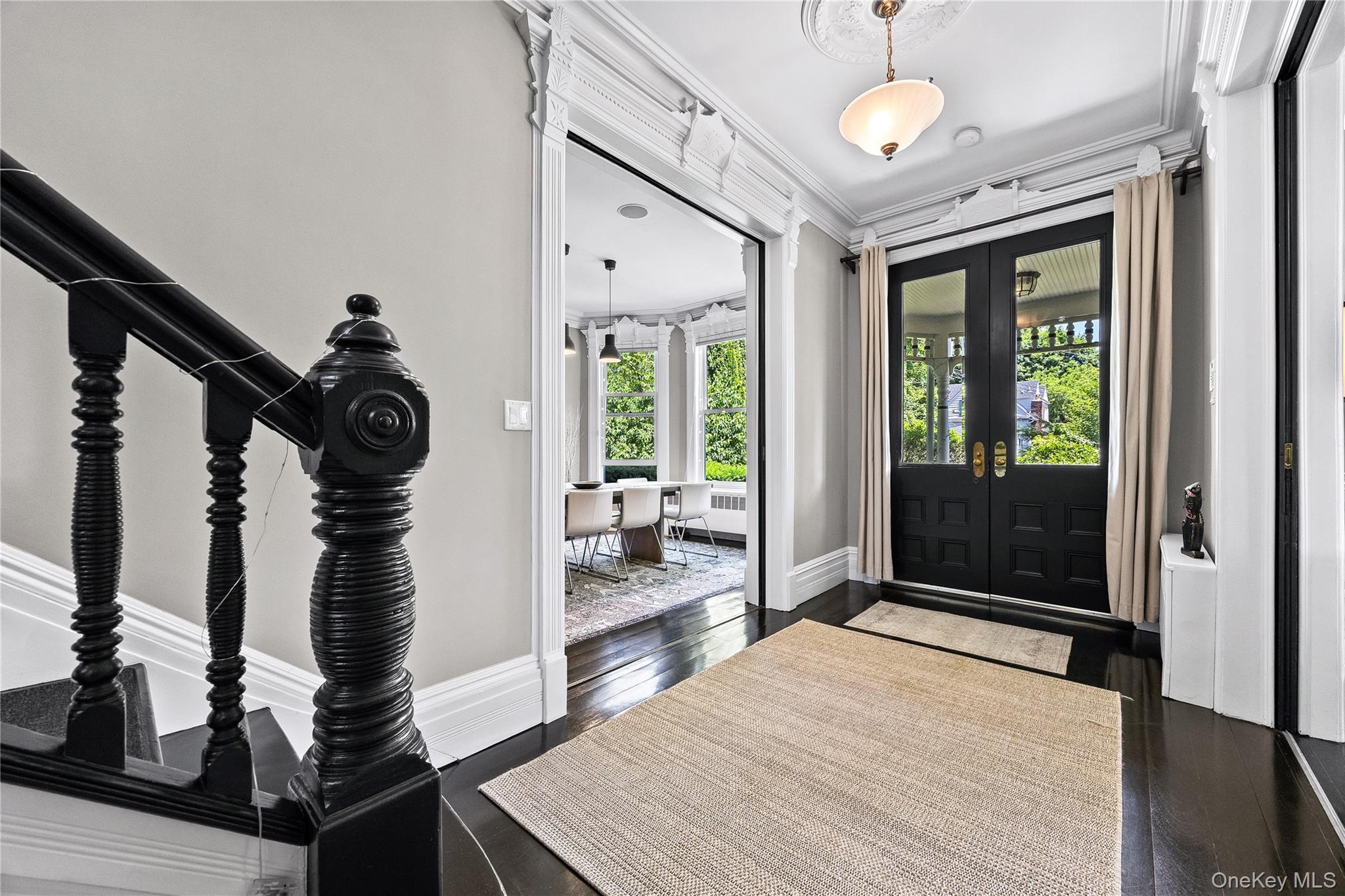 19 Howe Place Bronxville, NY 10708 - Photo 3 of 37 Grand foyer featuring dark wood-finish flooring and a black painted staircase with decorative newel post