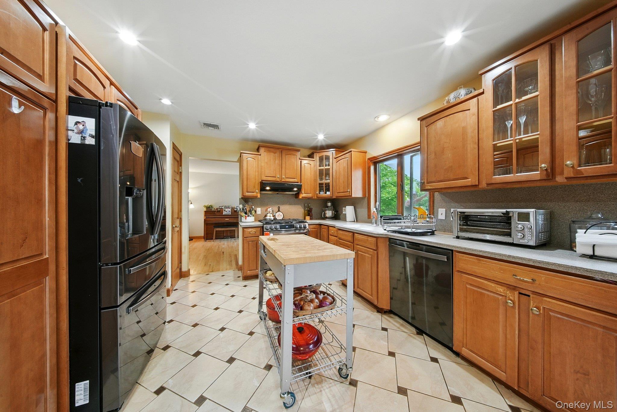 193 Dill Road Forestburgh, NY 12777 - Photo 12 of 31 Kitchen featuring appliances with stainless steel finishes, exhaust hood, glass insert cabinets, brown cabinets, and recessed lighting