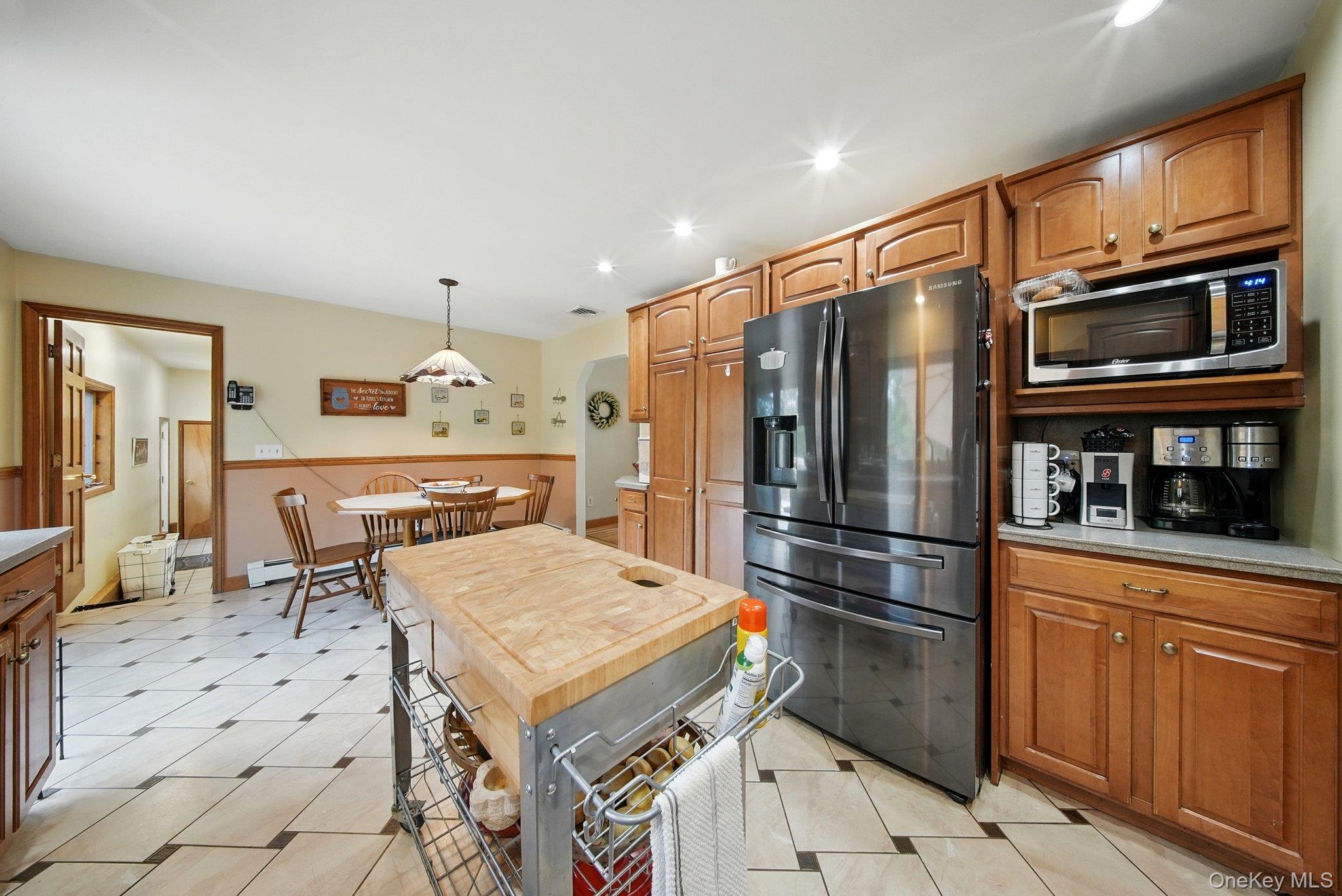 193 Dill Road Forestburgh, NY 12777 - Photo 15 of 31 Kitchen with refrigerator with ice dispenser, stainless steel microwave, light countertops, brown cabinetry, and recessed lighting