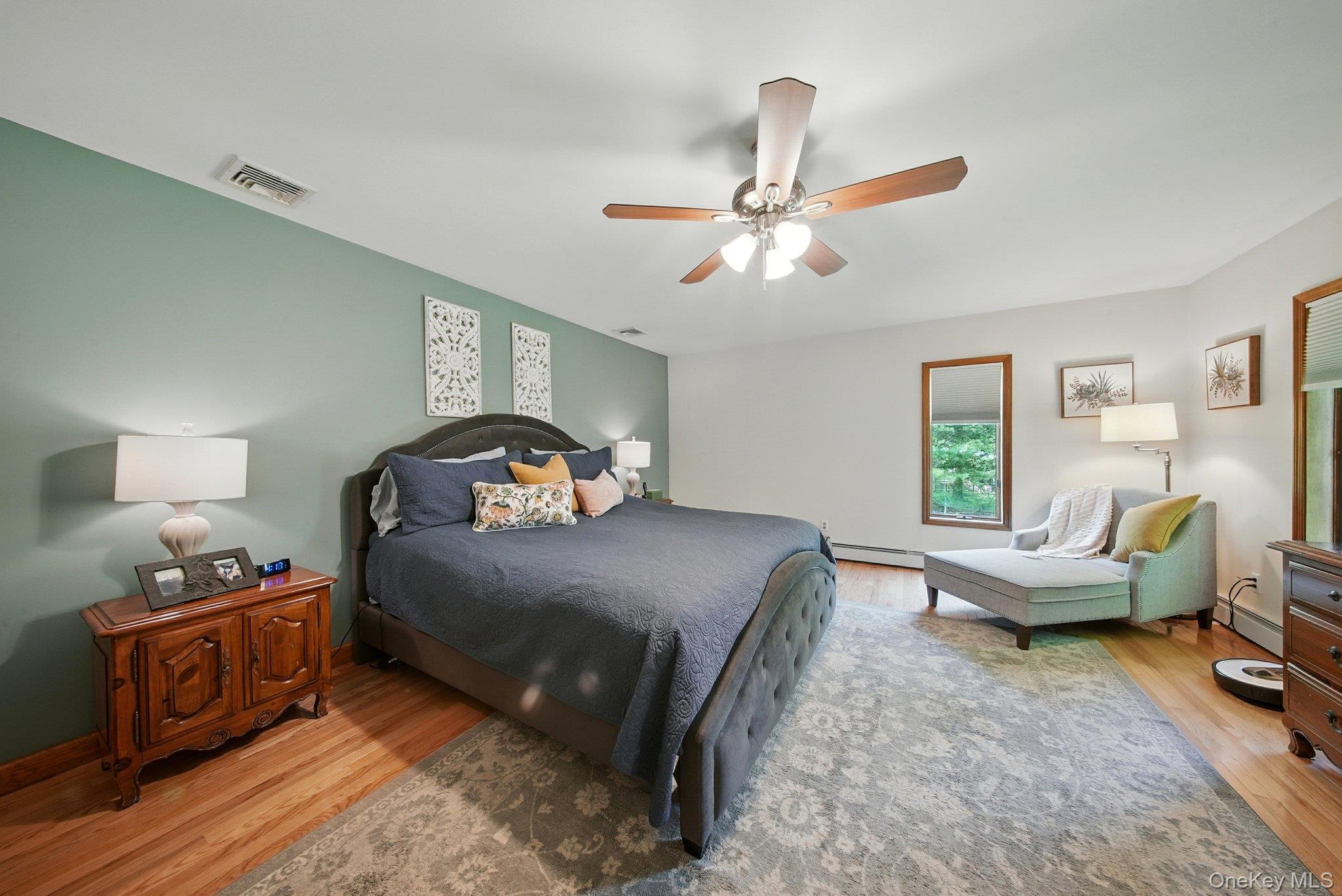 193 Dill Road Forestburgh, NY 12777 - Photo 17 of 31 Bedroom featuring a baseboard heating unit, wood finished floors, and a ceiling fan