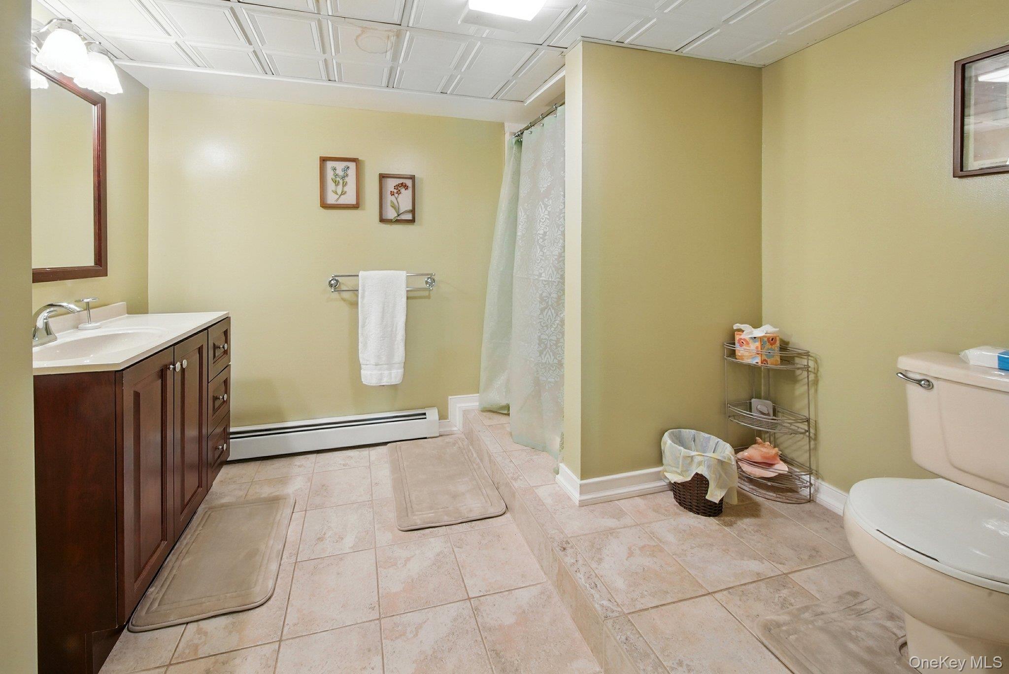 193 Dill Road Forestburgh, NY 12777 - Photo 21 of 31 Bathroom with a baseboard heating unit, vanity, a shower with shower curtain, and tile patterned flooring
