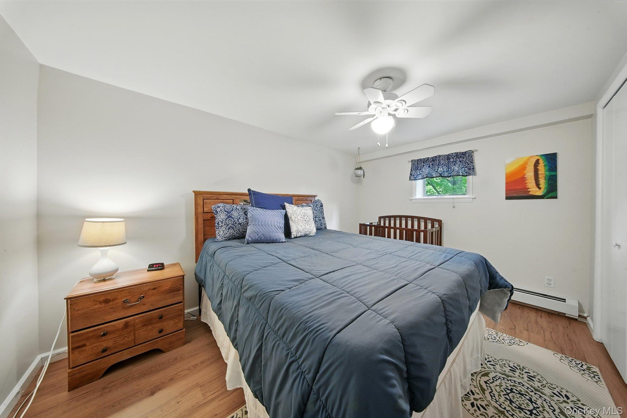 193 Dill Road Forestburgh, NY 12777 - Photo 22 of 31 Bedroom featuring a baseboard radiator, light wood finished floors, and ceiling fan
