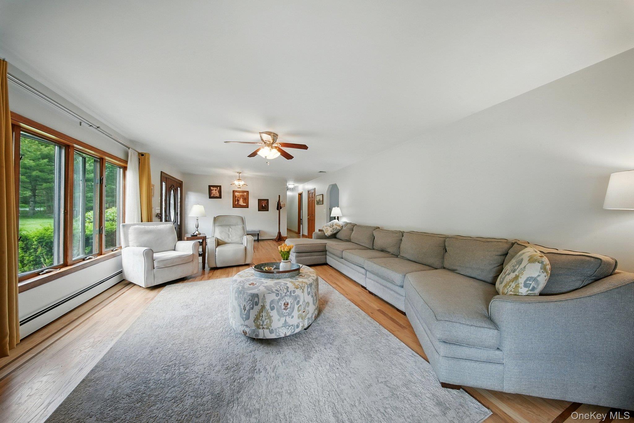 193 Dill Road Forestburgh, NY 12777 - Photo 7 of 31 Living room featuring a baseboard radiator, wood finished floors, and ceiling fan