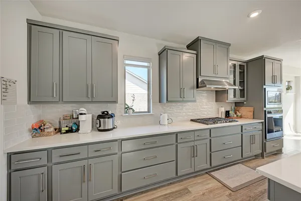 a kitchen with a sink cabinets and a large window