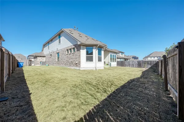 a view of a backyard with a chair and wooden fence
