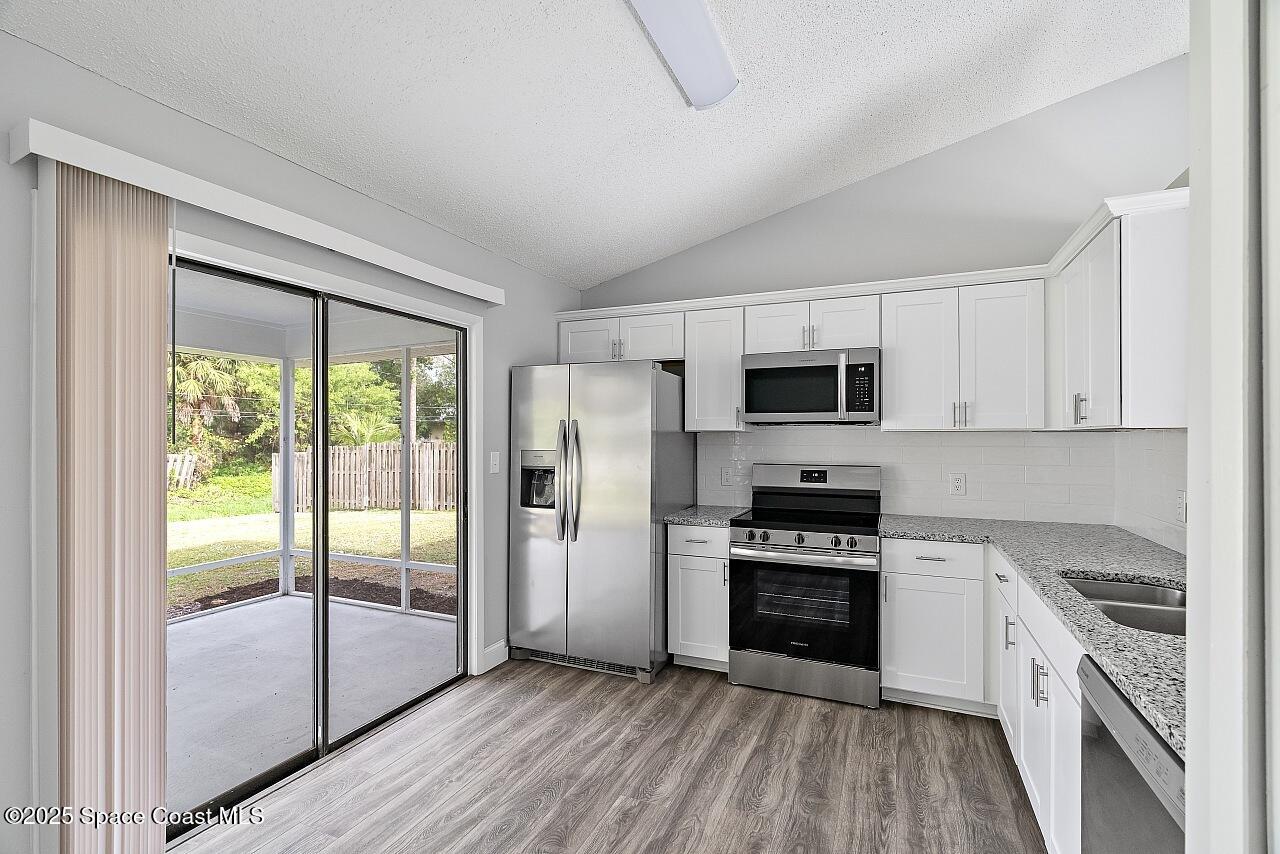 914 Devon Avenue Sebastian, FL 32958 - Photo 13 of 40 a kitchen with stainless steel appliances a stove top oven a sink and a refrigerator