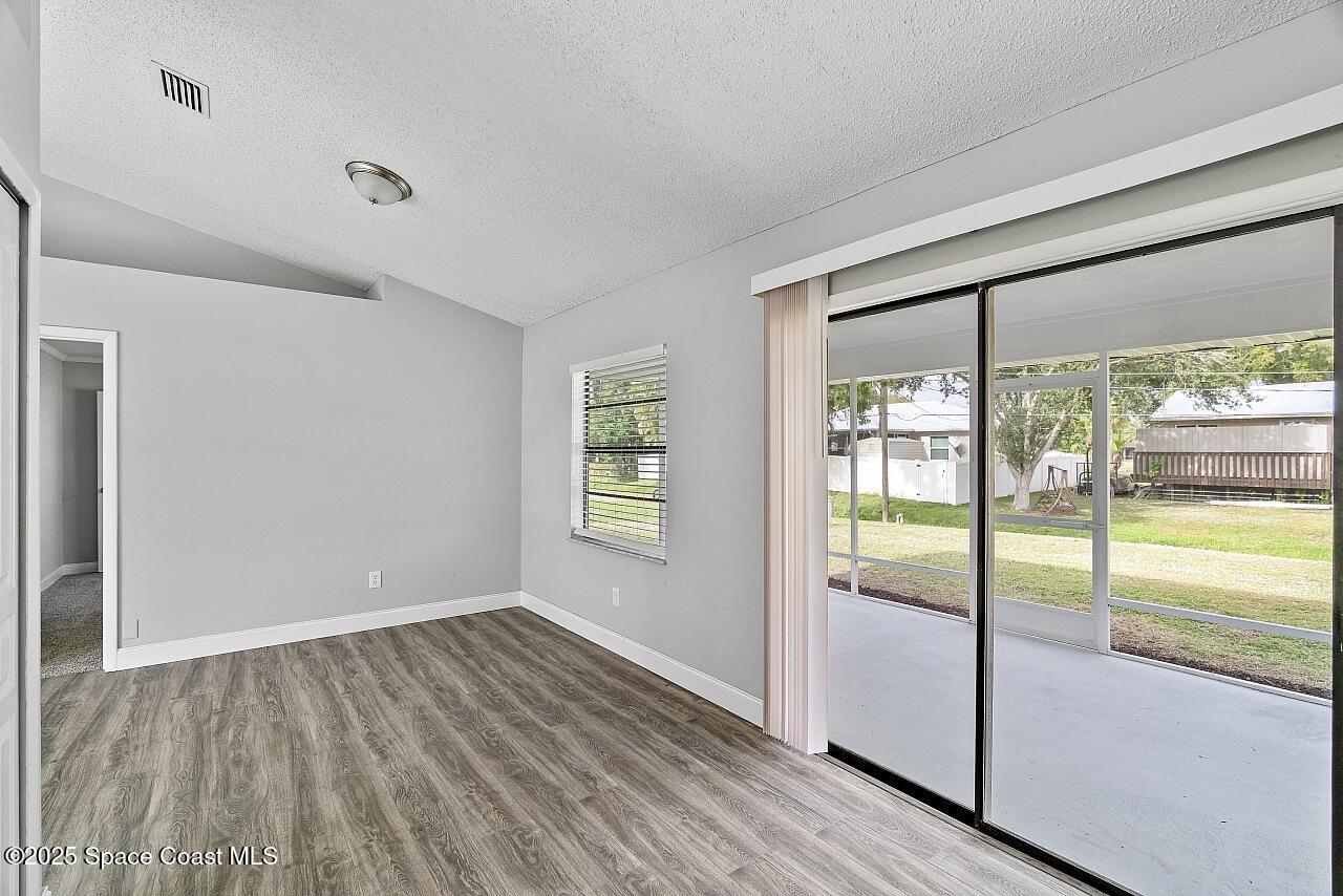 914 Devon Avenue Sebastian, FL 32958 - Photo 18 of 40 a view of an empty room with wooden floor and a window
