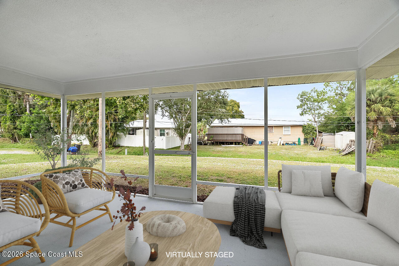 914 Devon Avenue Sebastian, FL 32958 - Photo 19 of 40 a living room with furniture and floor to ceiling windows