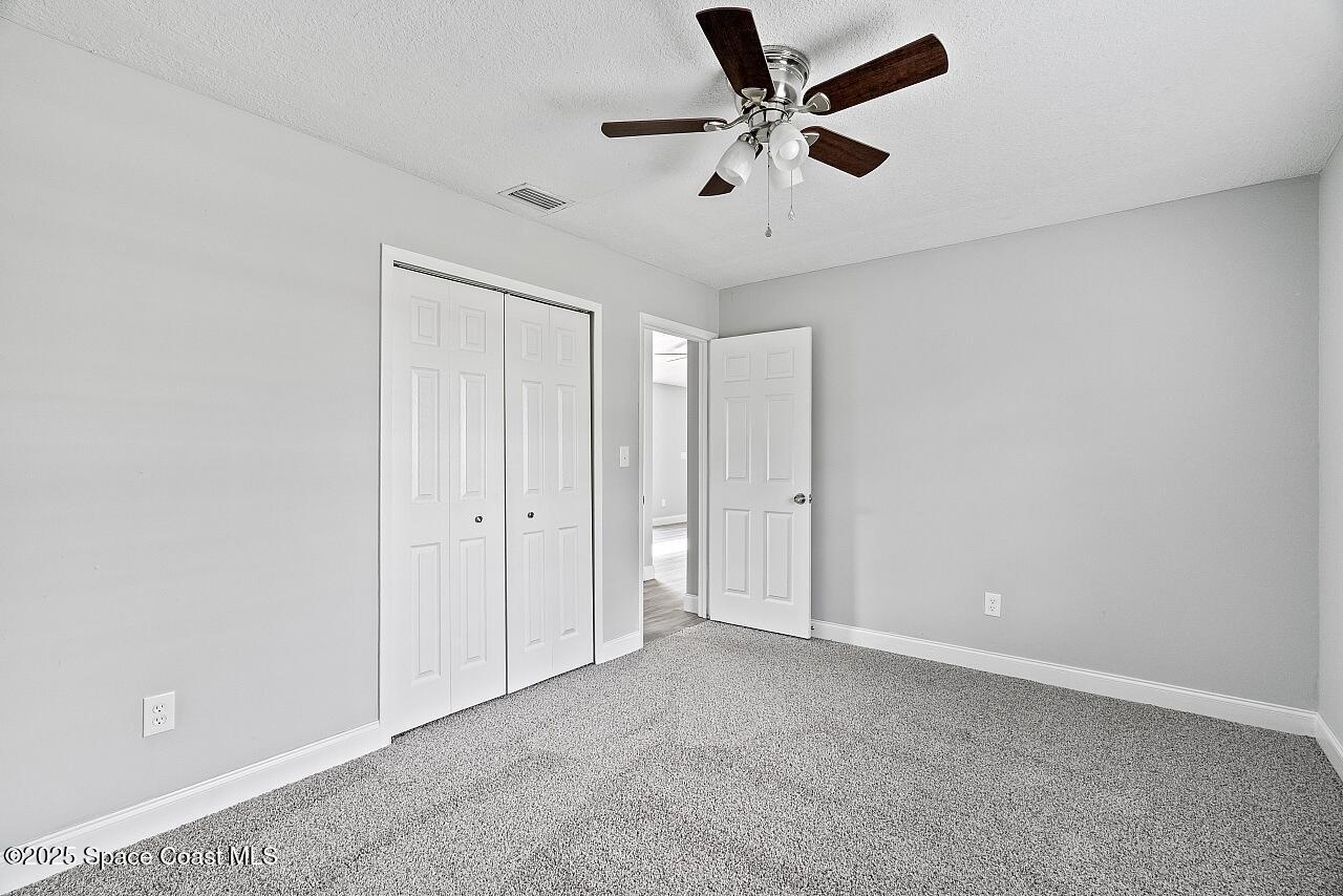 914 Devon Avenue Sebastian, FL 32958 - Photo 29 of 40 an empty room with a ceiling fan and carpet