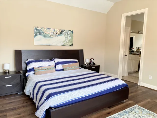 a bedroom with bed and wooden floor