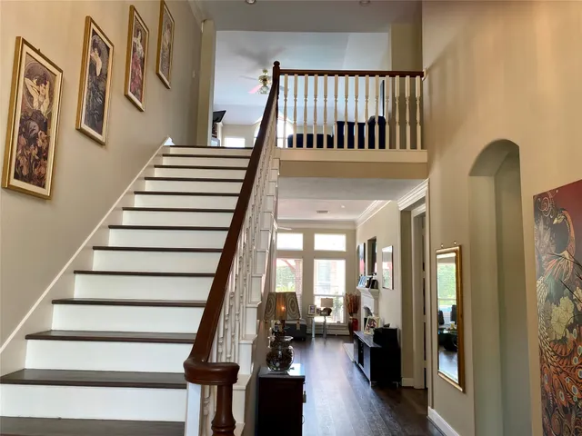 a view of staircase with lots of frames on wall and a window