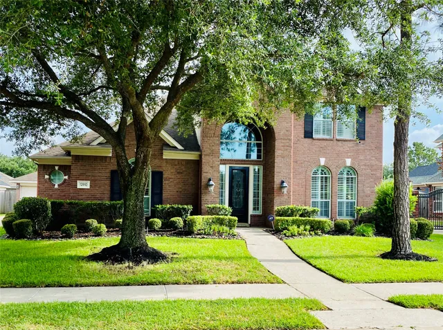 a front view of a house with a yard and a garden