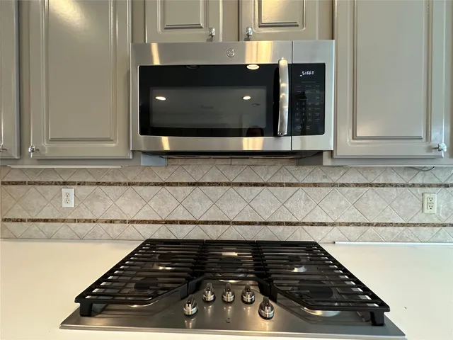 a kitchen with stove and cabinets