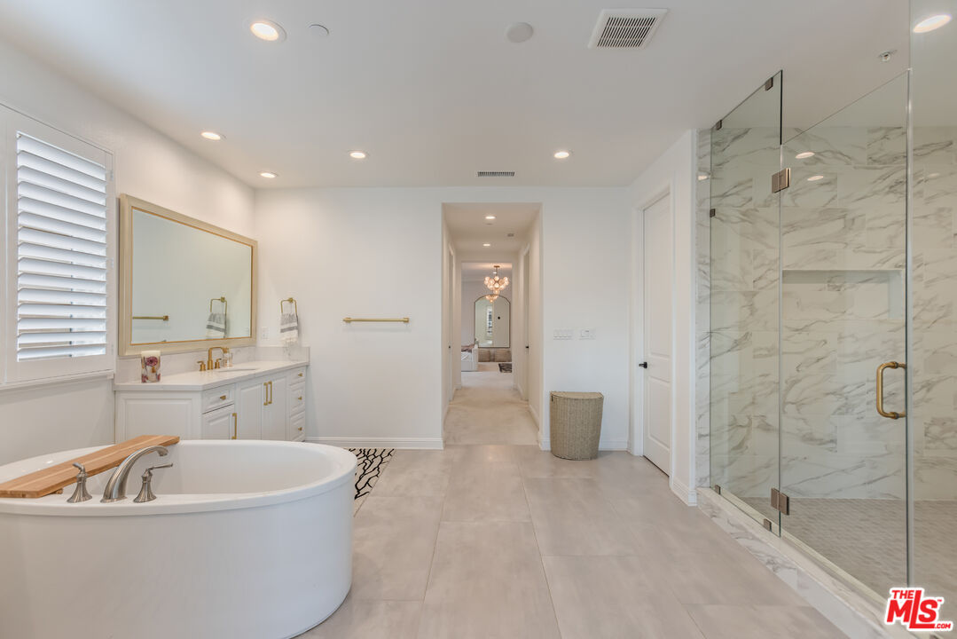 11734 Manchester Way Porter Ranch, CA 91326 - Photo 17 of 35 a spacious bathroom with a tub a sink shower and mirror