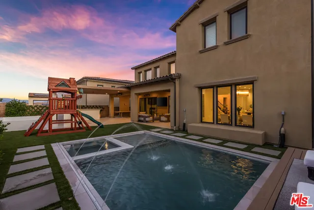 a view of a house with pool and chairs