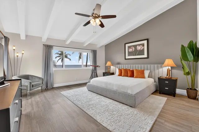 a bedroom with a large bed a chandelier and dresser