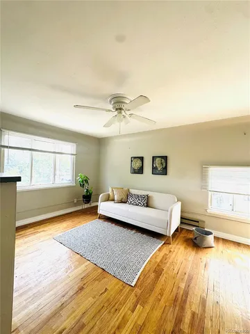 a living room with a bed furniture and next to a window