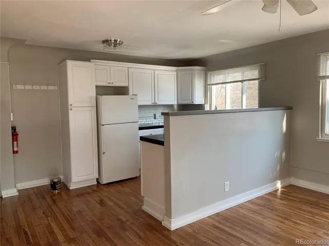 a kitchen with wooden floors and white appliances