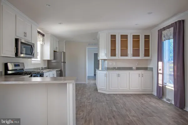 a kitchen with granite countertop cabinets stainless steel appliances a sink and wooden floor