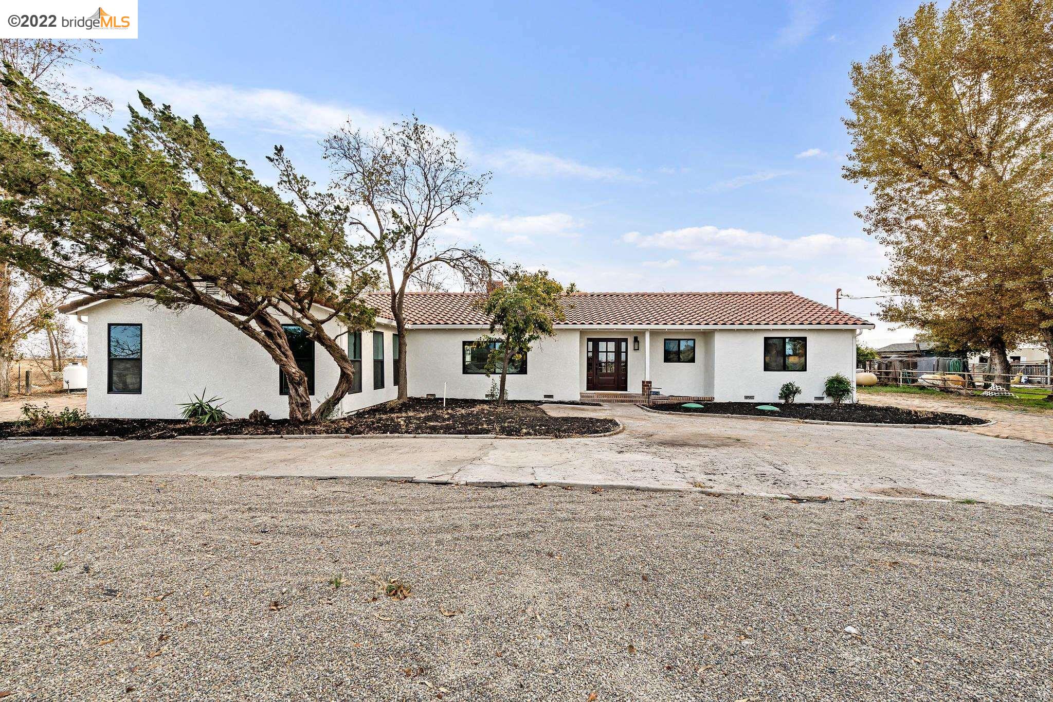 3343 Delta Road Brentwood, CA 94513 - Photo 1 of 1 a front view of a house with a dirt yard and a large tree